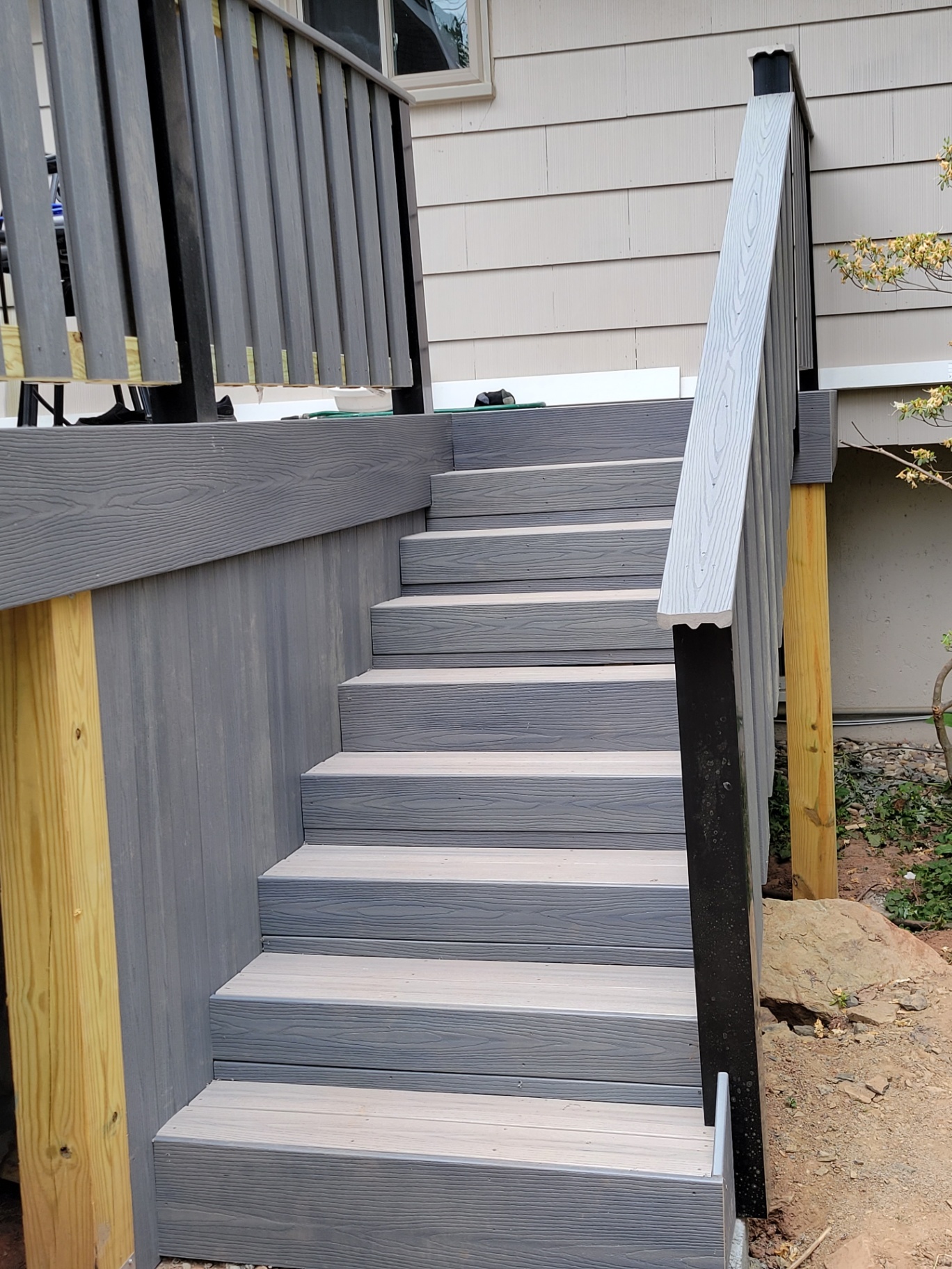 Composite deck stairs with two-tone treads and black balusters