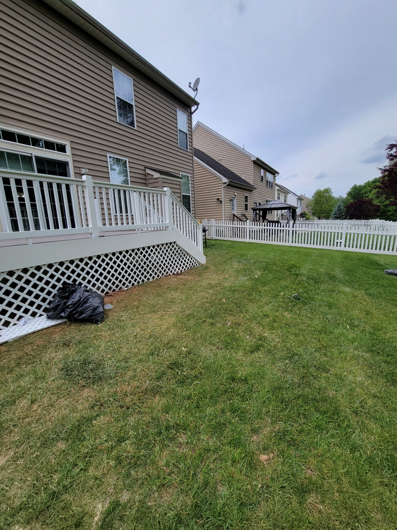 Elevated deck with white lattice skirting and picket fence