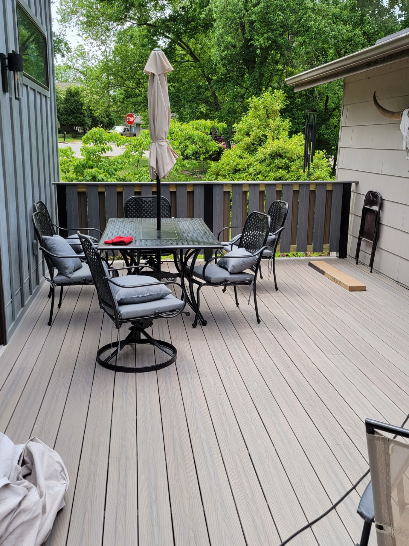 Finished composite deck with patio dining set and gray railings