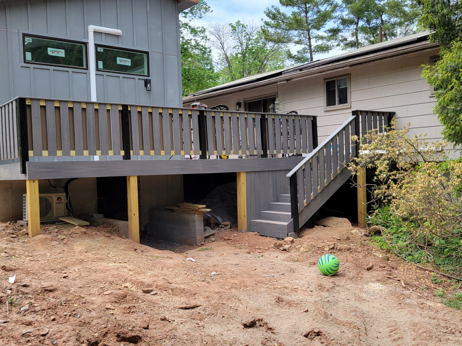 Elevated composite deck with stairs at the side of a home