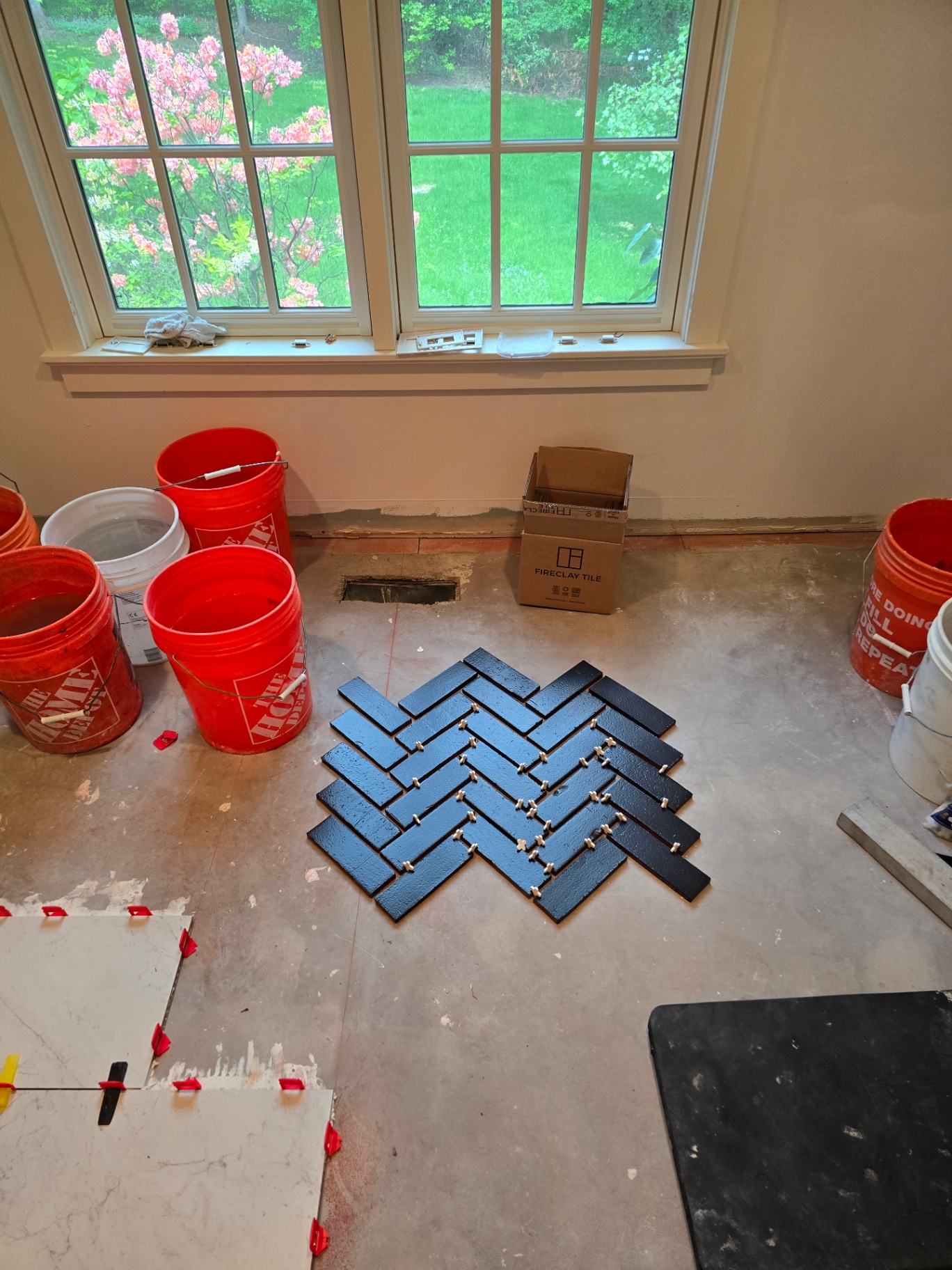 Herringbone tile floor layout in progress by a bay window