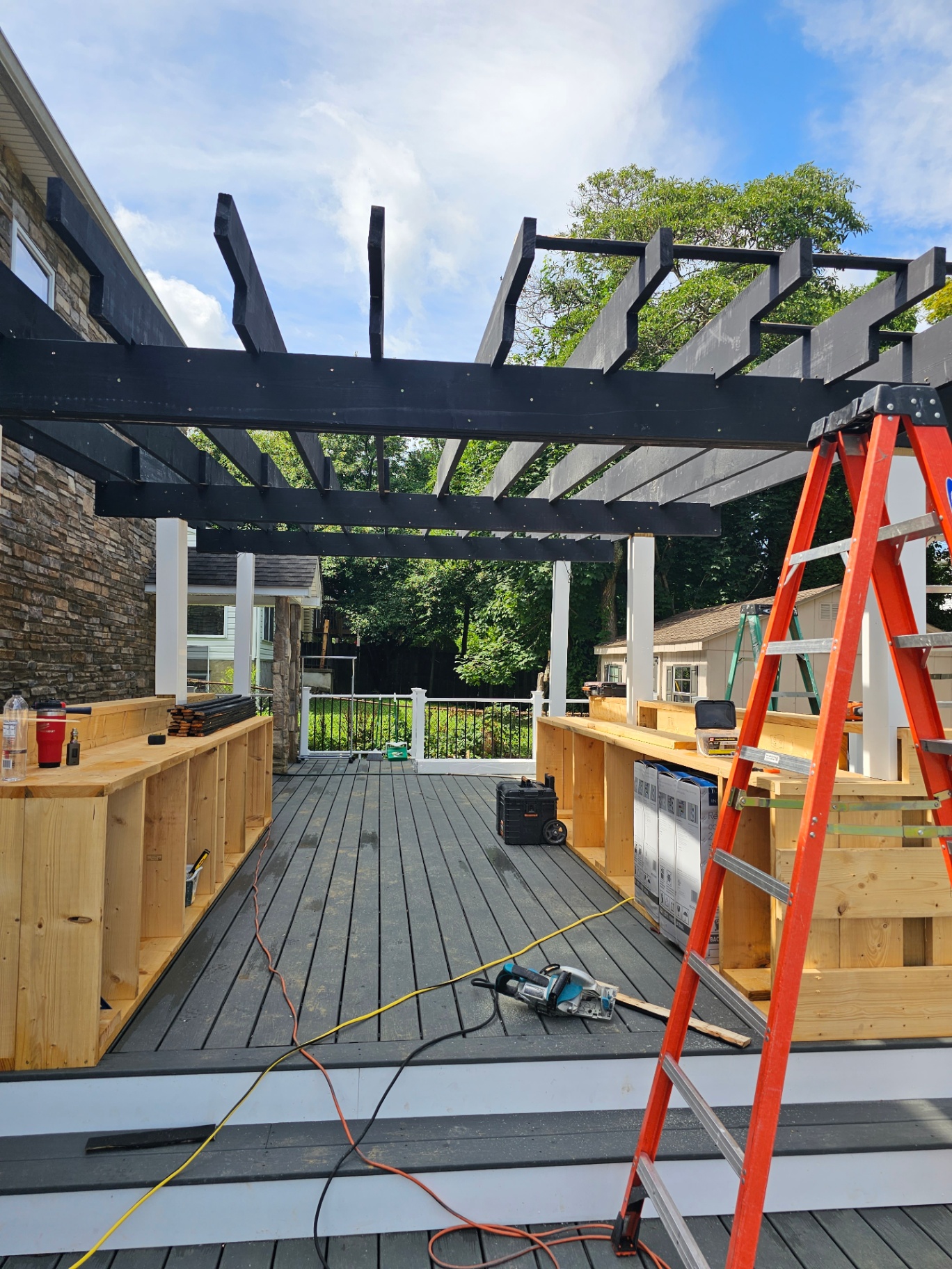 Outdoor kitchen build with black pergola on composite deck