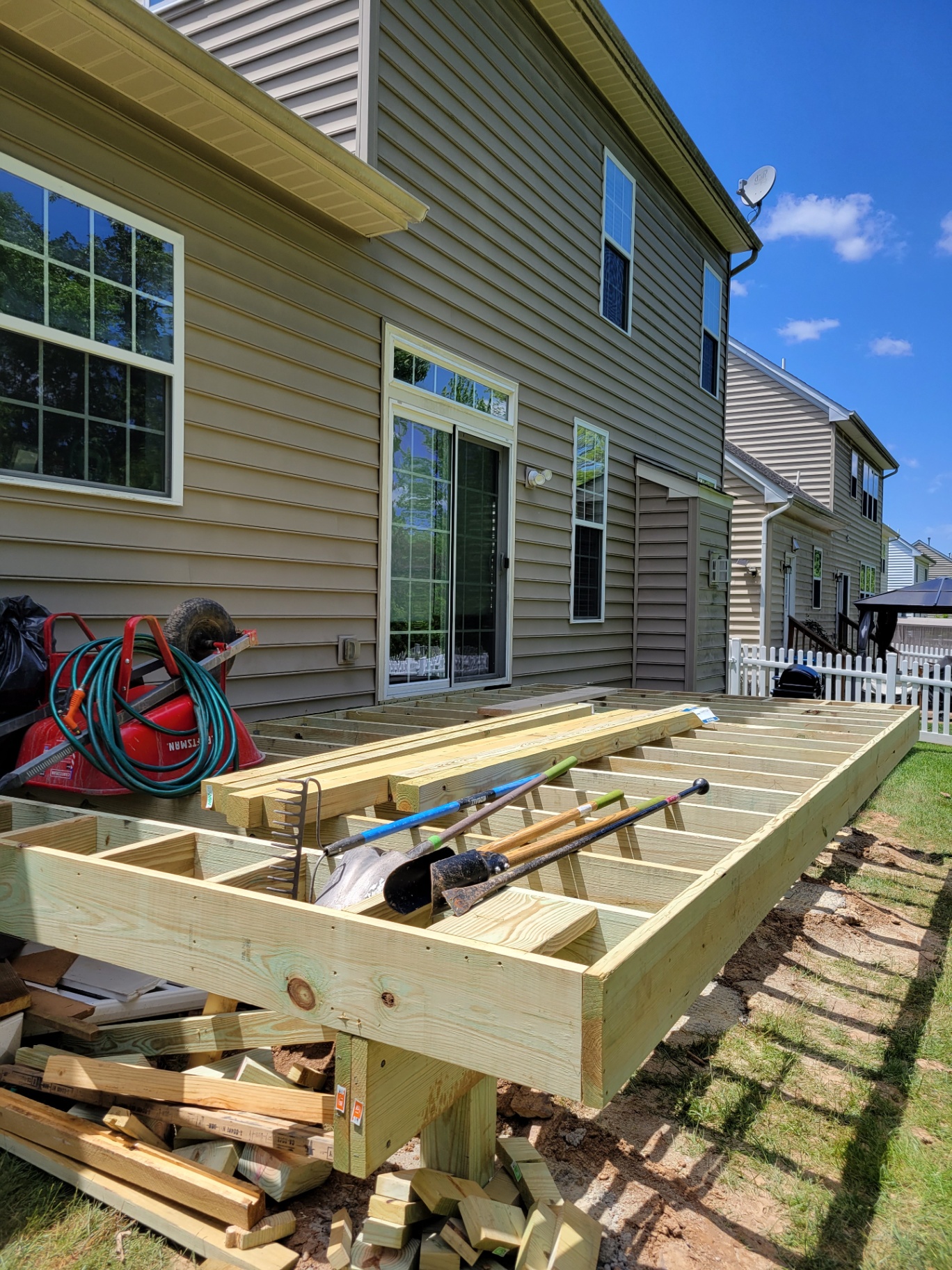 New pressure-treated deck framing along the back of a home